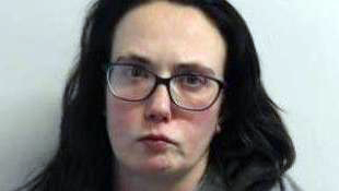 Police mugshot of Claire Kilduff who has dark hair and glasses.
