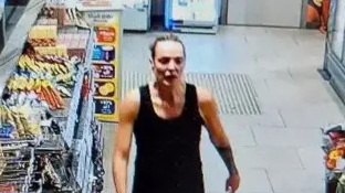 A CCTV footage screenshot of Rachel Booth walking through a supermarket. She is wearing an exercise top.