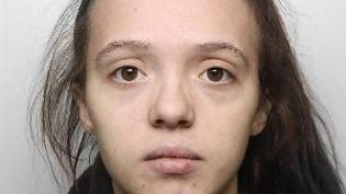 A mugshot of a woman with her brown hair in a ponytail.