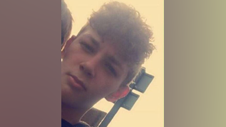 Cameron Gosling is a 14 year old boy who has curly brown hair and is looking at the camera.