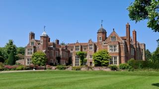 manor_house_with_bright_blue_sky_behind.