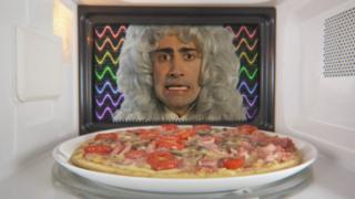 An old scientist in a wig is looking at a pizza in a microwave
