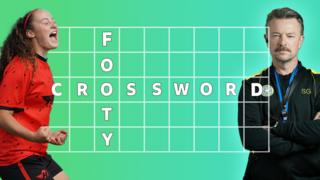 Christina and Mr Spence pose either side of a table with the words 'footy' and 'crossword' in it