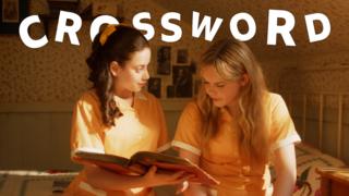 Girls dressed in Malory Towers school uniform reading a book sat down