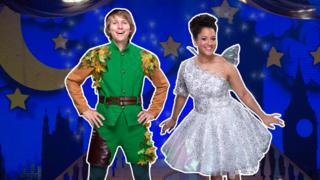 Peter Pan and Tinker Bell in front of the London skyline at night.