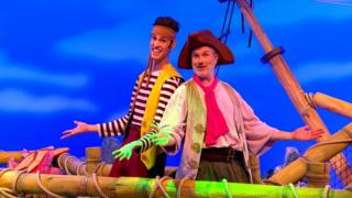 The pirates are singing a song on top of the ship.