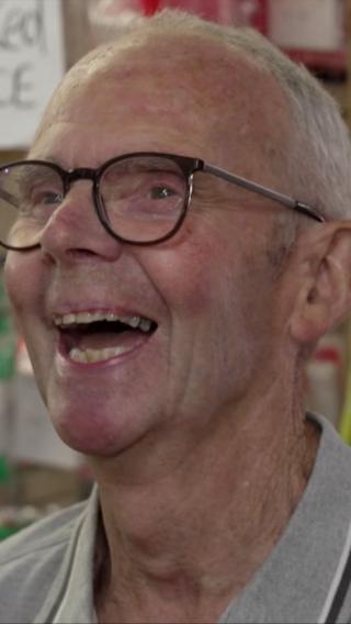 Patrick Meredith, he's a white man with glasses and grey hair. He's mid laugh, looking just away from the view of the camera.