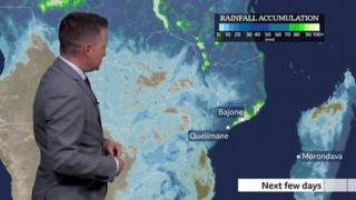 Matt Taylor stands in front of a weather map in southern Africa