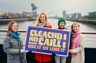 Sgioba Seachdain na Gàidhlig le soidhne air a bheil Cleachd i no Caill i is iad a' cur air bhog Seachdain na Gàidhlig 2026