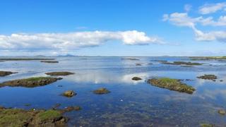 Blue skies with fluffy white clouds are seen over Lochcarnan in the Western Isles