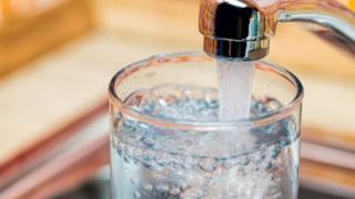 water pouring into glass tap