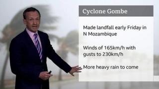 Nick Miller standing in front of a screen showing the wind speeds of Cyclone Gombe