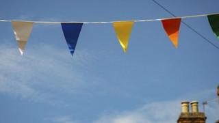 Multicoloured bunting across a blue sky