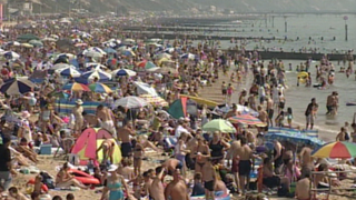 A crowded beach in the 1970s