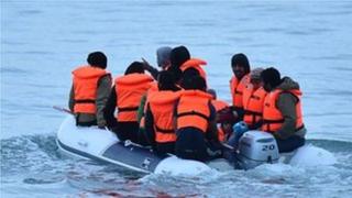 Migrants in a dinghy sail in the Channel toward the south coast of England
