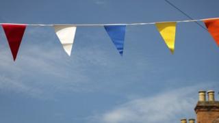 A string of bunting across a blue sky