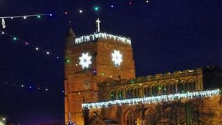 Christmas decorations on a church in Telford with deep blue sky behind