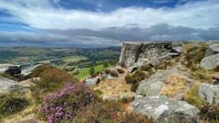 A blue and cloudy sky over the hills of Curbar, Derbyshire.