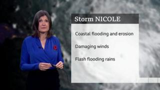 Helen Willetts stands in front of a card showing details of weather associated with Storm Nicole
