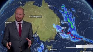 Darren Bett standing in front of a weather map of Australia