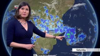 Helen Willetts stands in front of a weather map of Madagascar