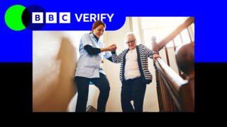 A care worker helps a woman down a flight of stairs