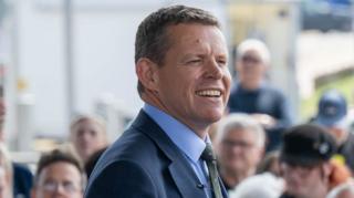 Rhun ap Iorwerth yn gwenu wrth annerch cefnogwyr ym Mae Caerdydd ddeuddydd wedi'r etholiad