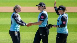 Surrey's Ryana MacDonald-Gay (left) celebrates a wicket with teammates
