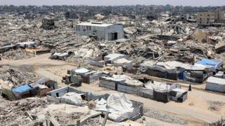A landscape shows sheer destruction across Gaza. Rubble, dust and dirt.