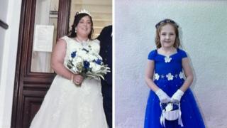 A composite image of Natalie McDonald and Valentina Foster. McDonald is wearing a white wedding dress with a tiara perched on her head. She has long dark hair and is holding a bouquet of white roses with four blue ones dotted within it. Valentina wears an electric blue dress with white flowers on the neckline and waist. She has long light brown hair with a blue and white headband. She is holding a small white basket with white and blue roses and she wears white gloves.