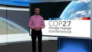 Ben Rich standing in front of a sign saying COP27