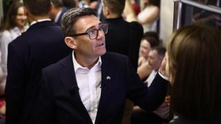 Andy Burnham reacts as he stands in a metro carriage among passengers during the journey between the metro stations Zoloti Vorota and Lukanivska on August 24, 2026 in Kyiv, Ukraine.