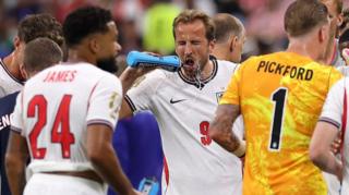 Harry Kane squirts water on his face during a hydration break in England's match against Croatia at the 2026 World Cup.