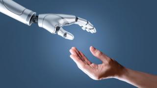 Robot arm and a human arm stretching out to each other