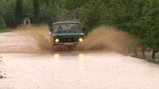 A car drives through flood water in Volos, Greece.