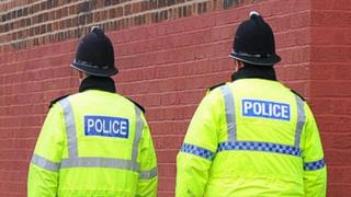 The back of two policeman's hi-vis jackets.