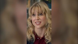 Amanda looks straight at the camera and smiles. She wears a burgundy polo shirt.
