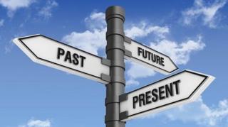 A picture of three arrow-shaped signs on a post, one says 'past', one says 'present', and the other says 'future'.