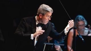 A conductor performing at the BBC Proms