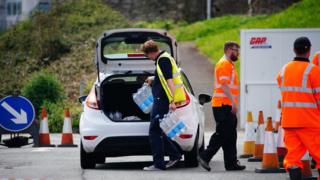 A shot of a car queuing to collect packs of bottled water at Freshwater car park in Brixham after a Boil Water Notice was issued. Households and businesses were advised not to use their tap water without boiling it first OR to use bottled water instead after traces of cryptosporidium were found in the water supply network