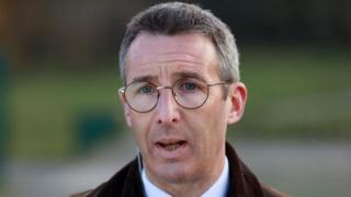 A man with glasses and short dark, greying hair