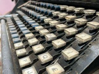 An image of an old-fashioned typesetting machine with big square keys with letters on them