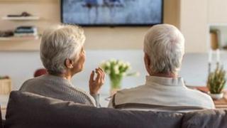 Two pensioners watching TV