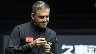 Ronnie O'Sullivan chalks his cue
