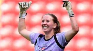 Sophie Whitehouse celebrates with arms raised and big smile