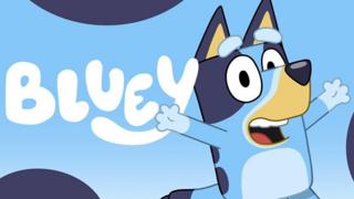 Bluey, a cartoon of a young blue dog, she is smiling and cheering.