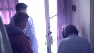 Two men scamming a vulnerable elderly woman