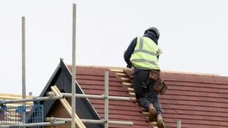 Generic image of a construction worker fixing roof tiles