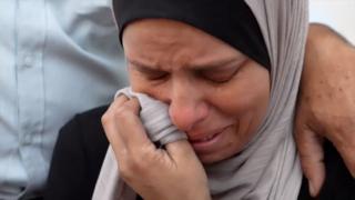 Woman in a headscarf crying.