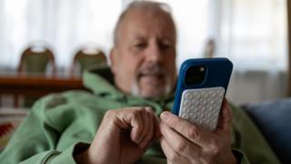 Elderly man using smartphone with silikon saugnapf - stock photo